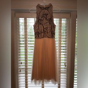 Knee length formal dress. A pinkish color with sequin details on the top.